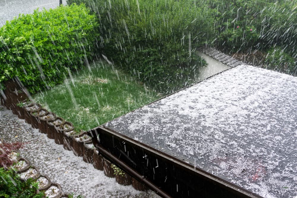 Hail pelts a house roof during a hailstorm.