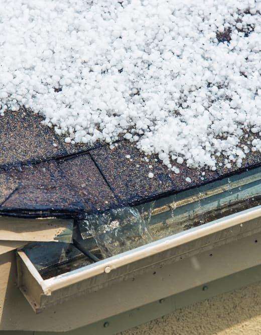 Melting hail accumulates on the roof, illustrating the impact of severe weather.