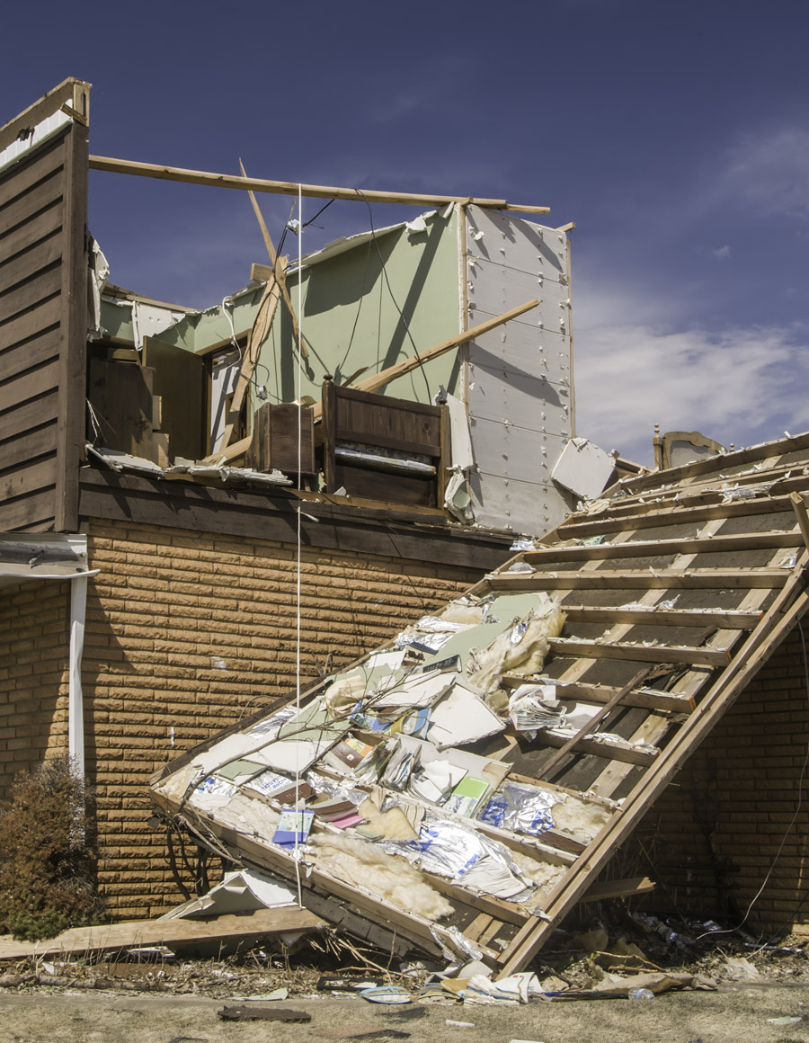 Tornado damage, with the roof torn off and interior materials exposed, requiring tornado insurance claim lawyer